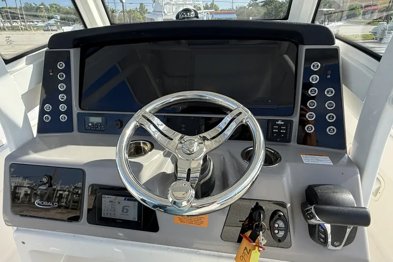 Slide: The Image of Helm of 2023 Robalo 266 Cayman boat with modern controls and steering wheel. - 16