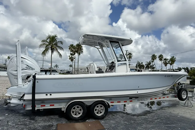 Slide: The Image of 2023 Robalo 266 Cayman boat on trailer, parked with palm trees in background. - 4
