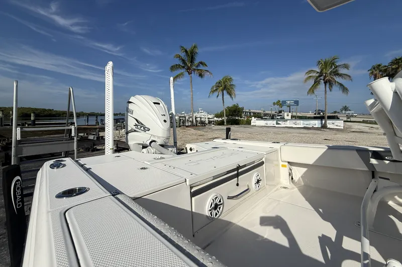 Slide: The Image of 2023 Robalo 266 Cayman boat with Yamaha engine, docked near palm trees. - 15
