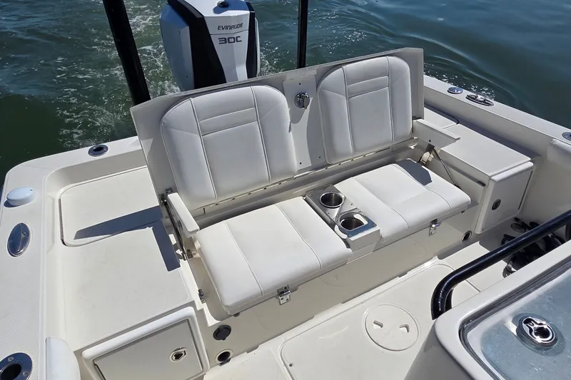 Slide: The Image of 2016 Ranger 2510 Bay Ranger boat interior with white seating and Evinrude motor. - 8