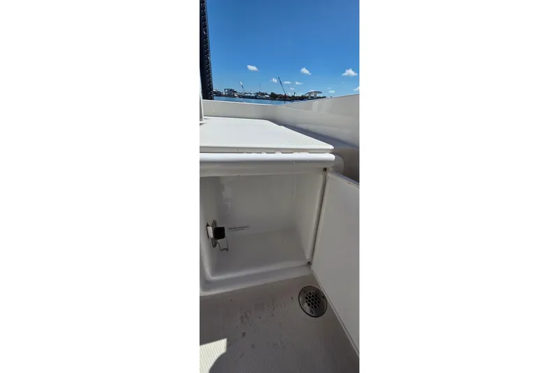 Slide: The Image of Open storage compartment on 2016 Ranger 2510 Bay Ranger boat under clear blue sky. - 10