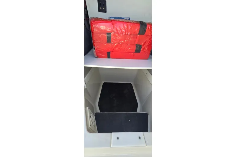 Slide: The Image of 2016 Ranger 2510 Bay Ranger storage compartment with red life jackets. - 26