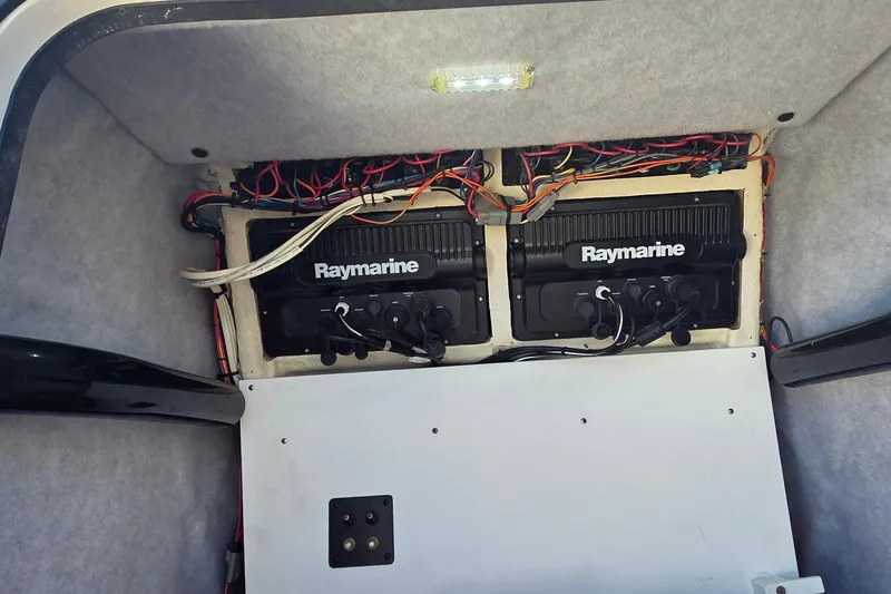 Slide: The Image of 2016 Ranger 2510 Bay Ranger electronics compartment with Raymarine equipment and wiring. - 27