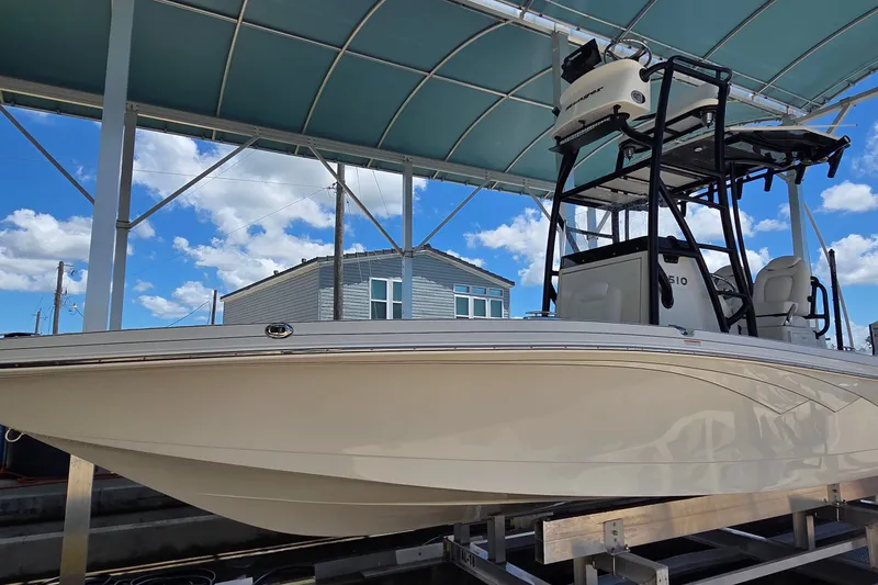 Slide: The Image of 2016 Ranger 2510 Bay Ranger boat under a canopy with blue sky background. - 63
