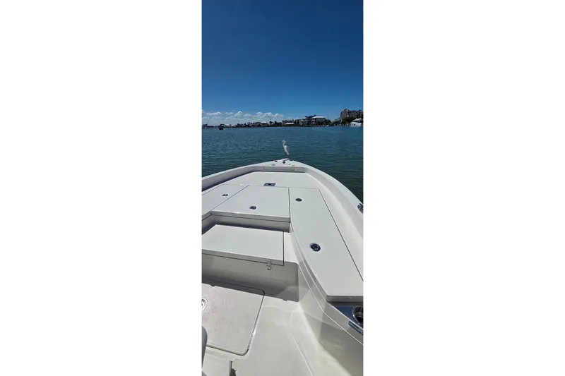 Slide: The Image of 2016 Ranger 2510 Bay Ranger boat on calm water under clear blue sky. - 45