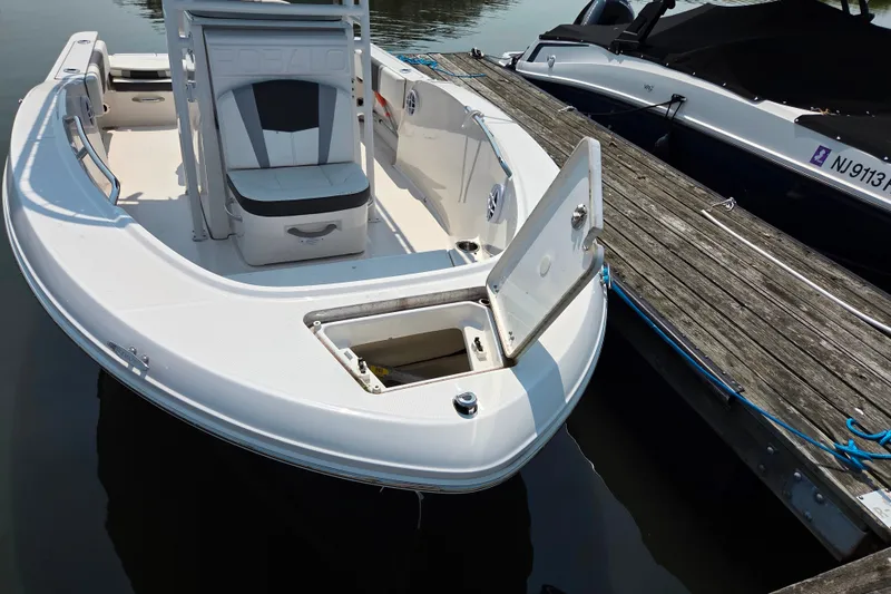 Slide: The Image of 2025 Robalo R180 Center Console boat docked, featuring open storage compartment. - 30