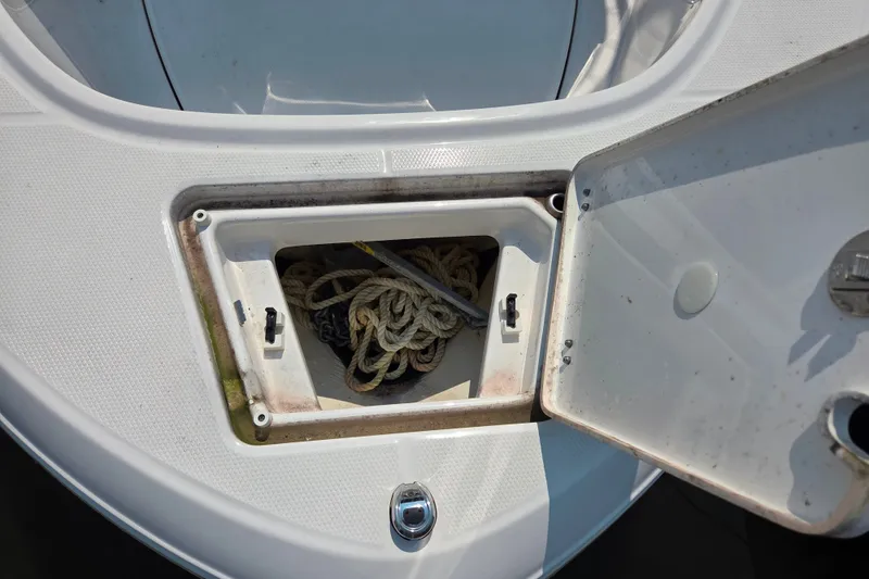 Slide: The Image of Open storage compartment on 2025 Robalo R180 Center Console boat with rope inside. - 31