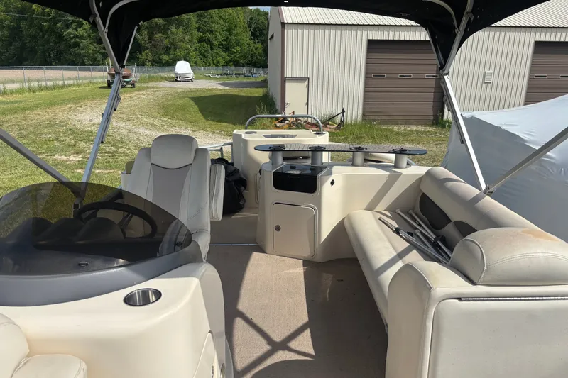 Slide: The Image of 2011 AquaPatio AP250W6 boat interior with seating and steering wheel under canopy. - 4