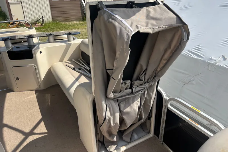 Slide: The Image of 2011 AquaPatio AP250W6 boat interior with folded canopy and seating area. - 7