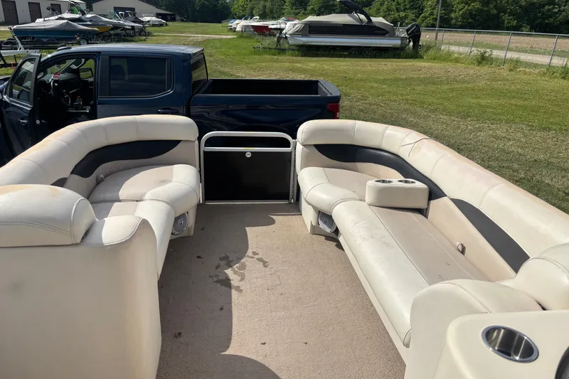 Slide: The Image of 2011 AquaPatio AP250W6 pontoon boat interior with beige seating and cup holders. - 5
