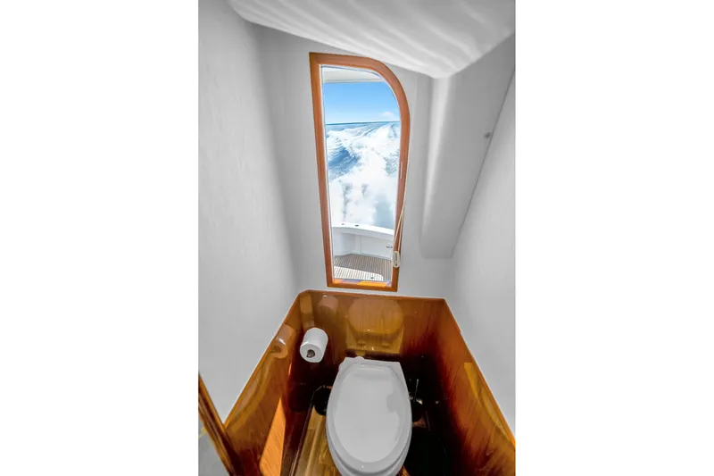 Slide: The Image of Bathroom view on 2012 Viking 76 Convertible yacht, featuring ocean scenery through door. - 61