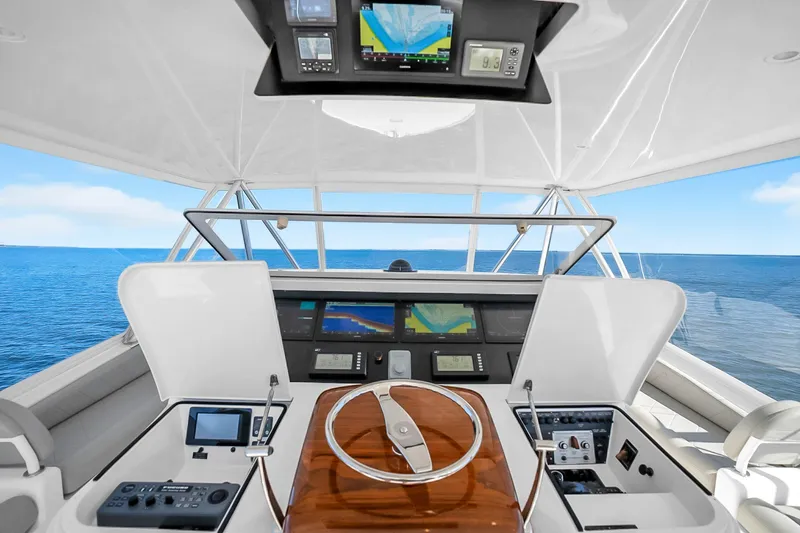 Slide: The Image of Helm of 2012 Viking 76 Convertible yacht with navigation equipment, steering wheel, and ocean view. - 34