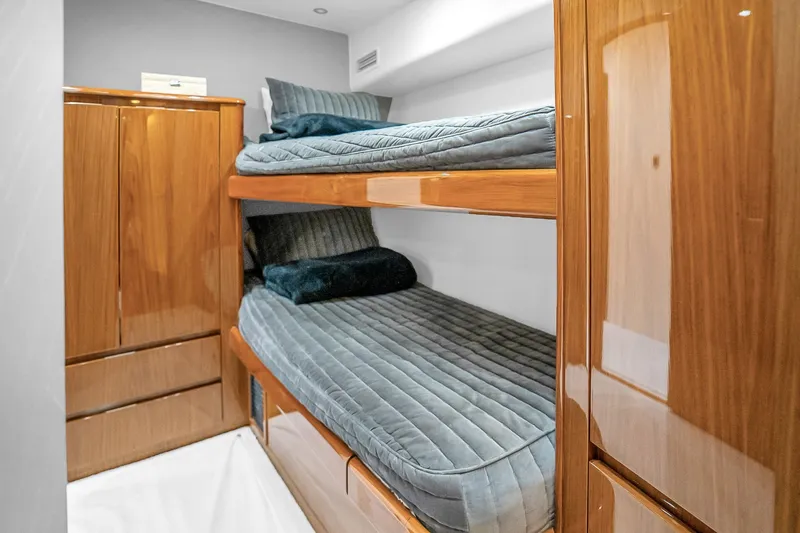 Slide: The Image of Bunk beds in a 2012 Viking 76 Convertible yacht cabin with wooden cabinetry. - 100