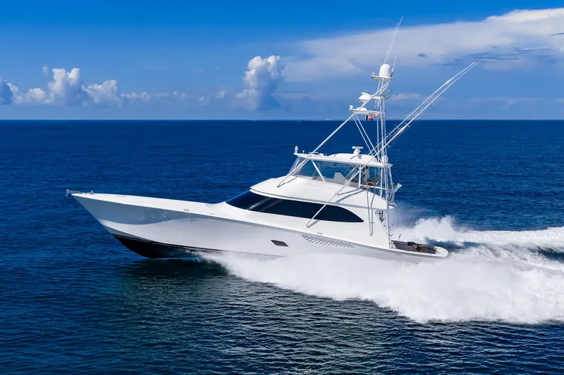 The Image of 2012 Viking 76 Convertible yacht cruising on open ocean under clear blue sky. - 0