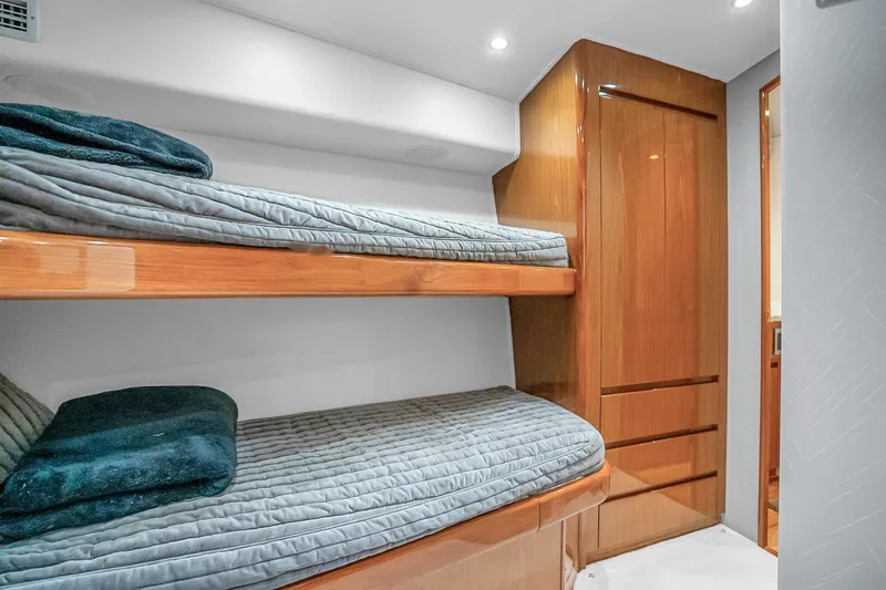 Slide: The Image of Interior of 2012 Viking 76 Convertible yacht with wooden bunk beds and cozy bedding. - 96