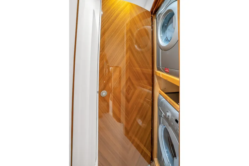 Slide: The Image of Laundry area with stacked washer and dryer in 2012 Viking 76 Convertible yacht. - 117