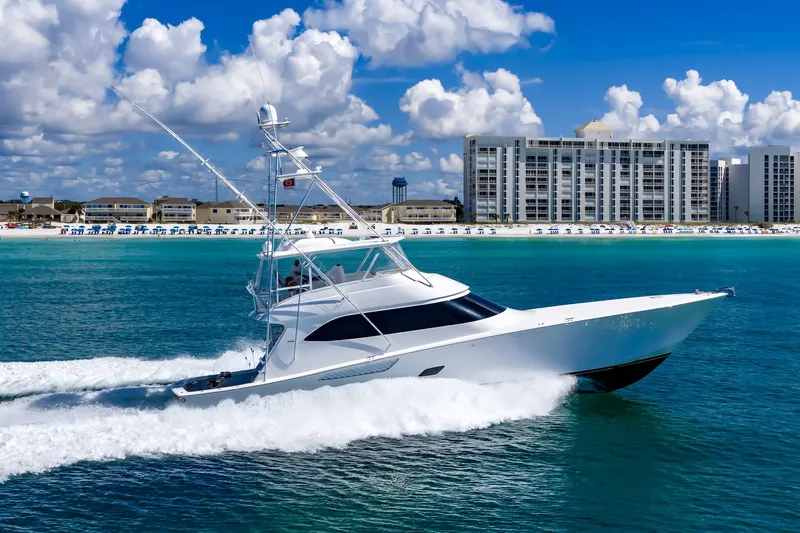 Slide: The Image of Luxury Viking 76 Convertible yacht cruising near a beachfront cityscape, 2012 model. - 19