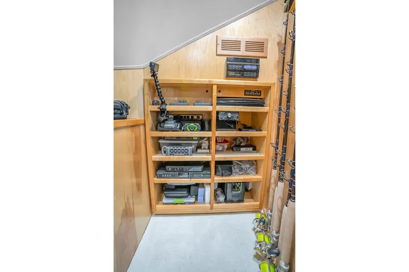 Slide: The Image of Storage shelves with fishing gear and equipment on a 2012 Viking 76 Convertible yacht. - 118