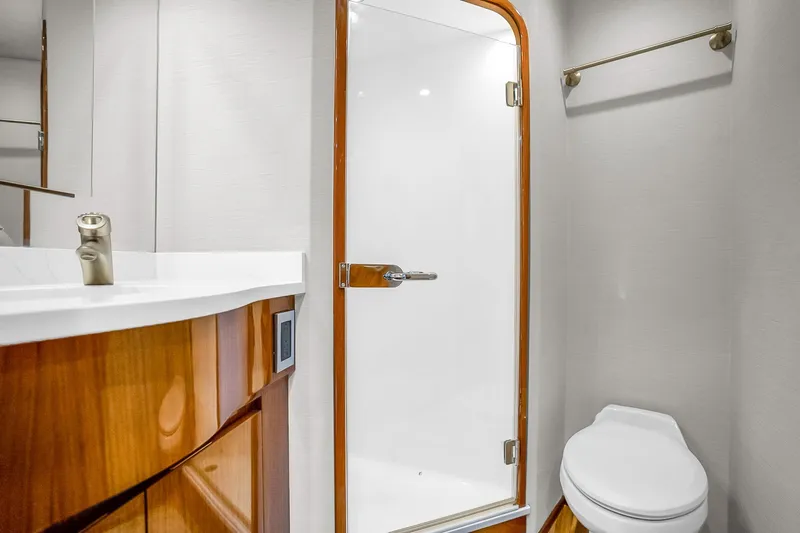 Slide: The Image of Luxurious bathroom in 2012 Viking 76 Convertible yacht with modern fixtures and wooden accents. - 112