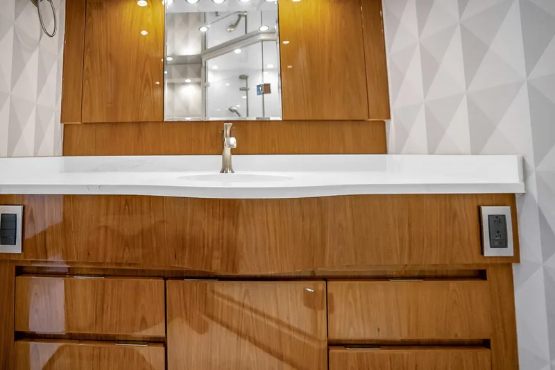 Slide: The Image of Luxurious wooden vanity with modern sink in 2012 Viking 76 Convertible yacht bathroom. - 88