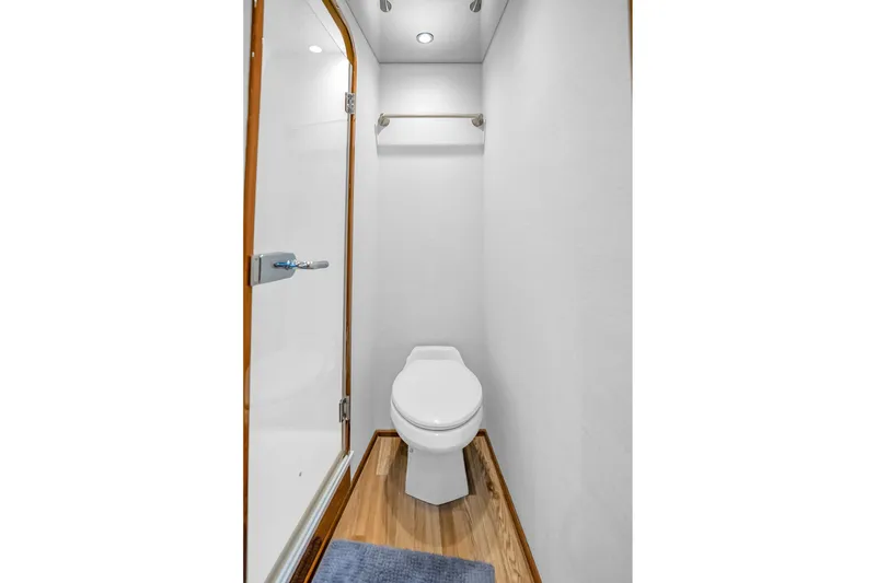 Slide: The Image of Compact bathroom in 2012 Viking 76 Convertible yacht with modern fixtures and wooden flooring. - 97