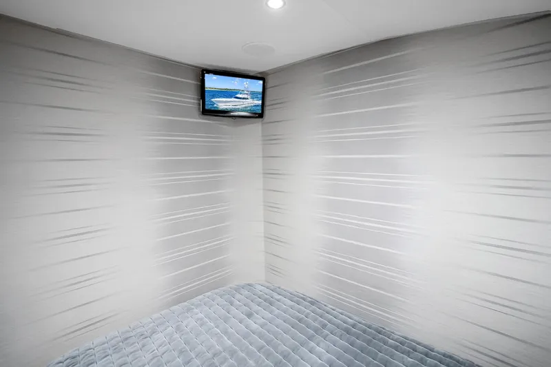Slide: The Image of Interior of 2012 Viking 76 Convertible yacht with wall-mounted TV and cozy bedding. - 104