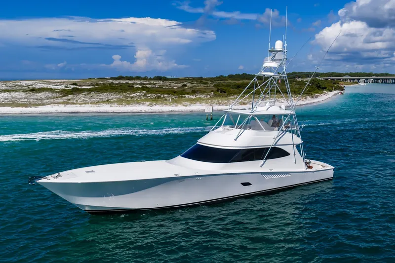 Slide: The Image of Luxury 2012 Viking 76 Convertible yacht cruising near a scenic shoreline. - 2