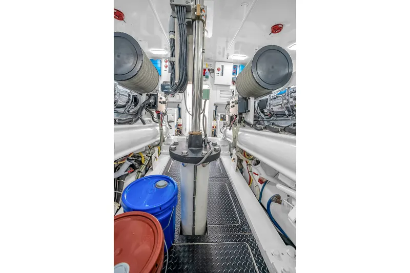 Slide: The Image of Engine room of 2012 Viking 76 Convertible yacht with visible machinery and storage barrels. - 132