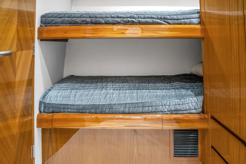 Slide: The Image of Bunk beds with blue bedding in 2012 Viking 76 Convertible yacht cabin. - 113