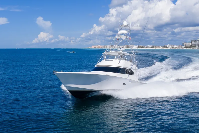 Slide: The Image of 2012 Viking 76 Convertible yacht cruising on blue ocean near coastline. - 22