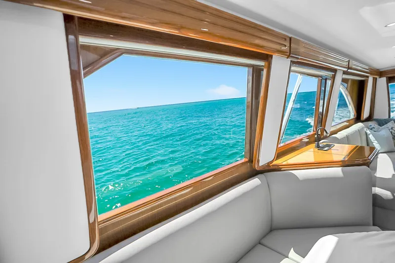 Slide: The Image of Interior view from a 2012 Viking 76 Convertible yacht, overlooking the ocean through large windows. - 80