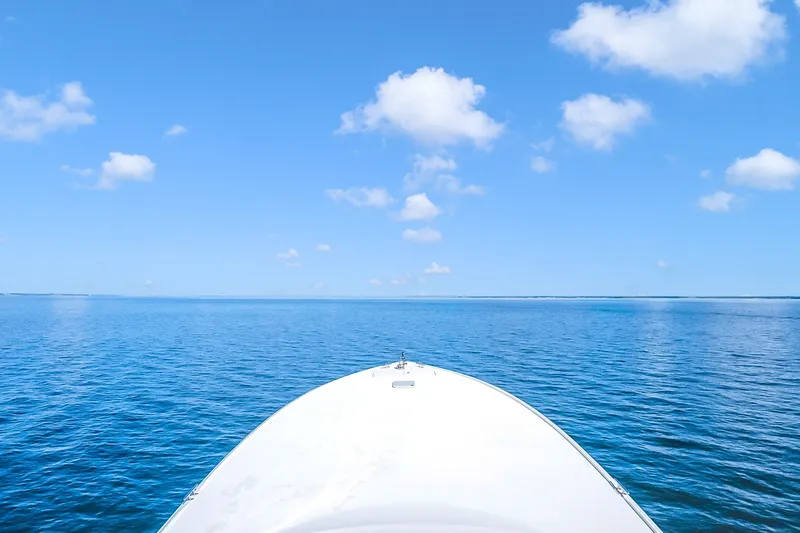 Slide: The Image of Bow of 2012 Viking 76 Convertible yacht on open sea under blue sky. - 43