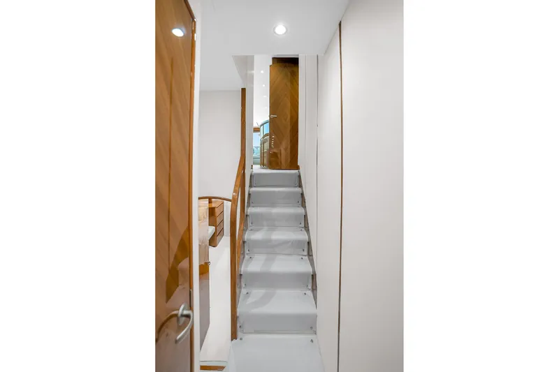 Slide: The Image of Interior staircase of 2012 Viking 76 Convertible yacht, featuring sleek wooden accents. - 116