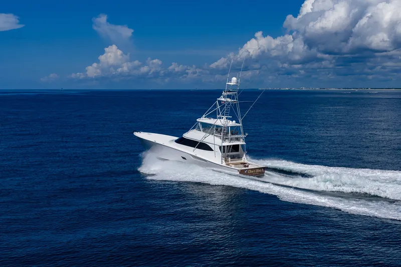 Slide: The Image of 2012 Viking 76 Convertible yacht cruising on open ocean under blue sky. - 23