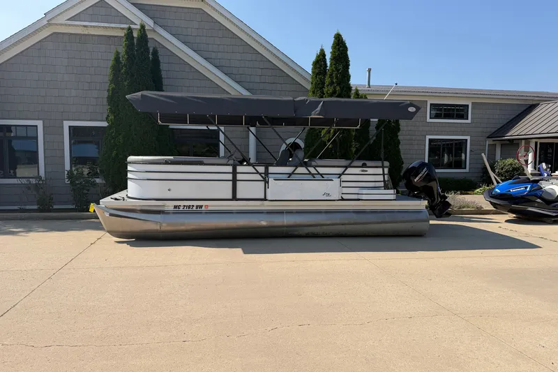 Slide: The Image of 2022 Crest Classic DLX 220 SLC pontoon boat parked outside a building. - 1