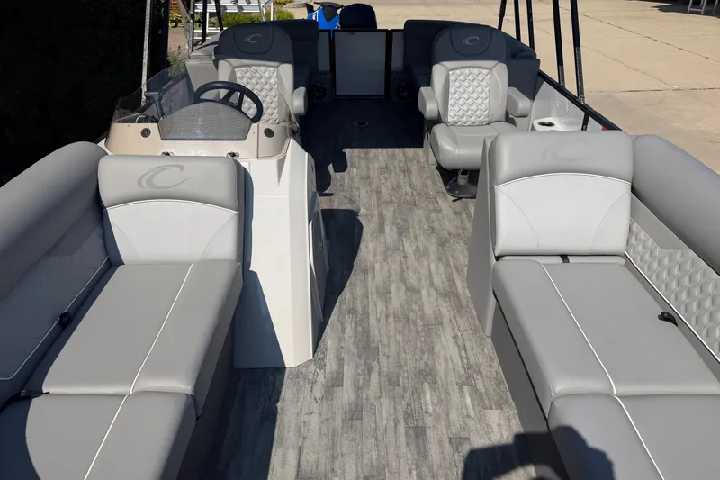 Slide: The Image of 2022 Crest Classic DLX 220 SLC pontoon boat interior with gray seating and steering console. - 5