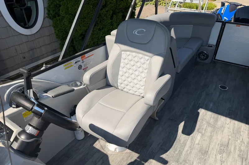 Slide: The Image of 2022 Crest Classic DLX 220 SLC boat interior with luxurious seating and modern steering console. - 12