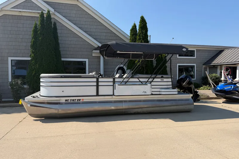 The Image of 2022 Crest Classic DLX 220 SLC pontoon boat parked outside a building. - 0