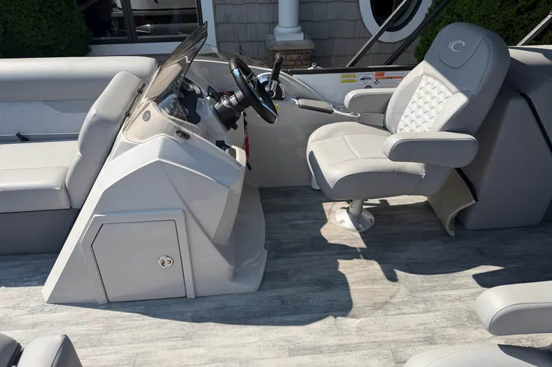 Slide: The Image of 2022 Crest Classic DLX 220 SLC boat interior with steering console and captain's chair. - 8