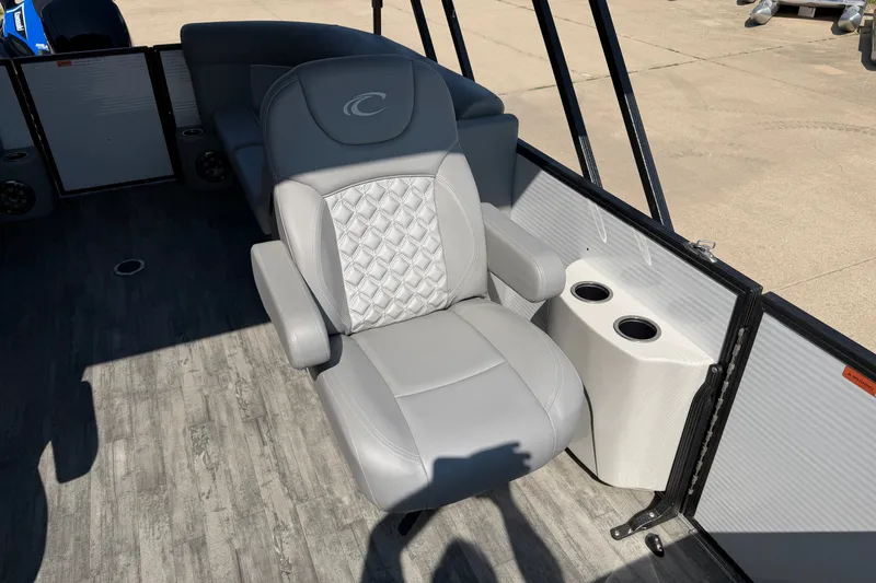 Slide: The Image of 2022 Crest Classic DLX 220 SLC boat interior with gray captain's chair and cup holders. - 11