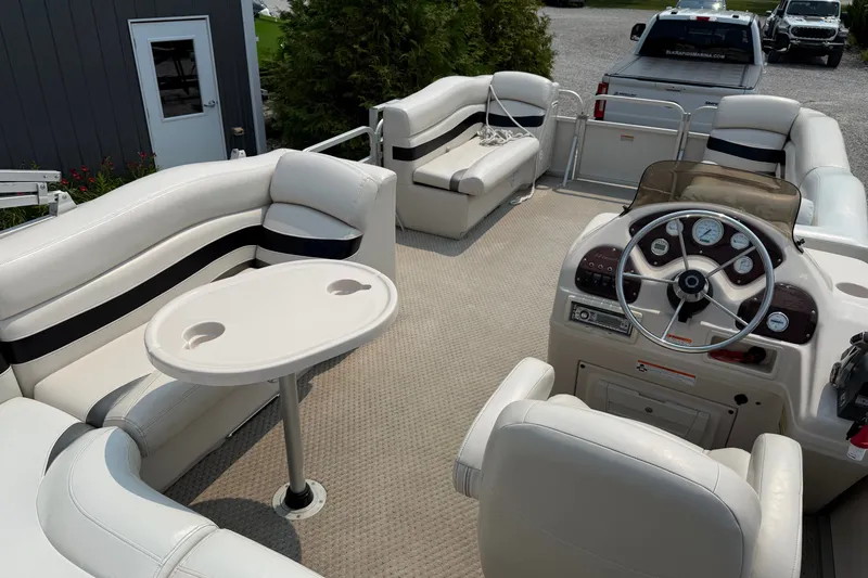 Slide: The Image of 2008 Manitou Oasis pontoon boat interior with steering console and seating area. - 13