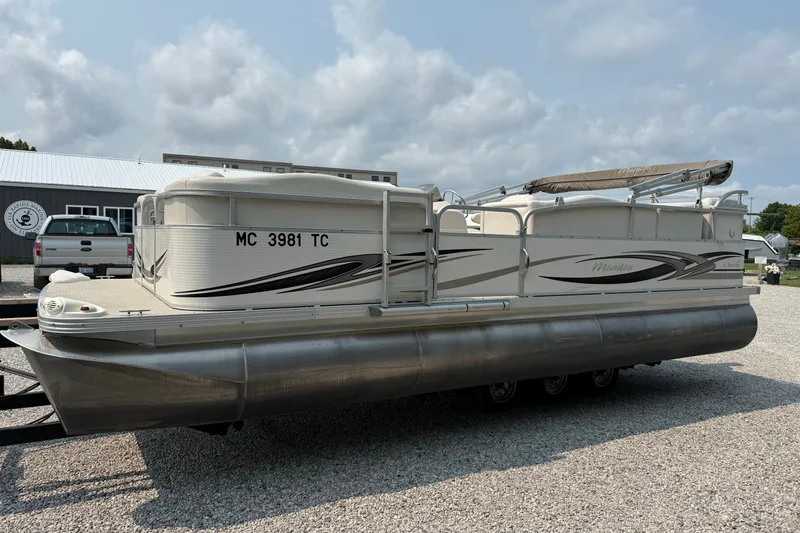 Slide: The Image of 2008 Manitou Oasis pontoon boat on gravel lot under cloudy sky. - 8