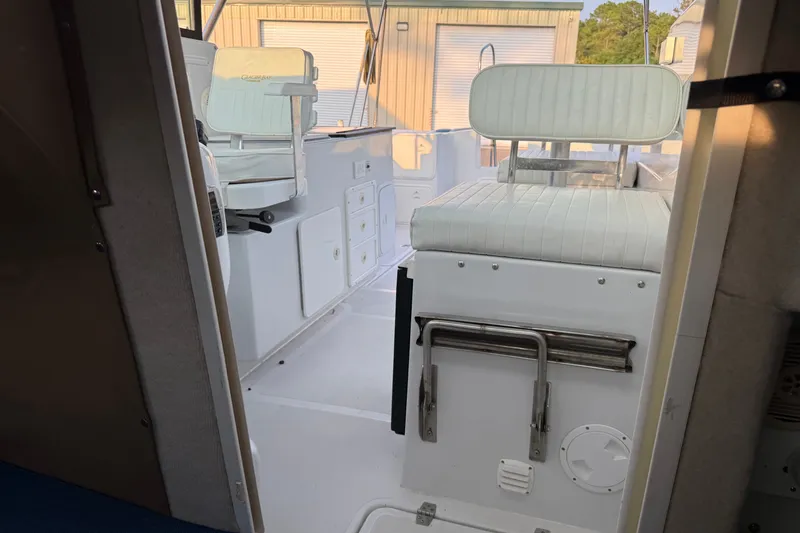 Slide: The Image of Interior view of a 2005 Glacier Bay 2685 Coastal Runner boat, featuring white seating and storage. - 14