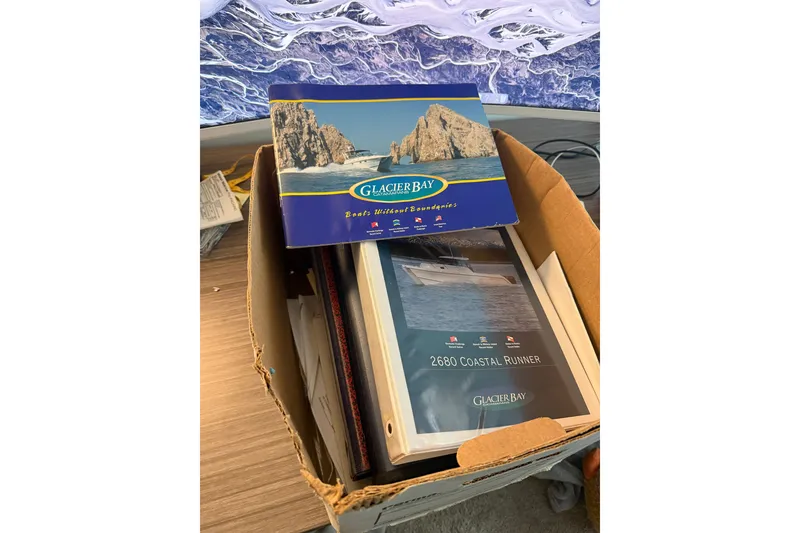 Slide: The Image of Box containing Glacier Bay 2685 Coastal Runner 2005 brochures on a wooden table. - 16