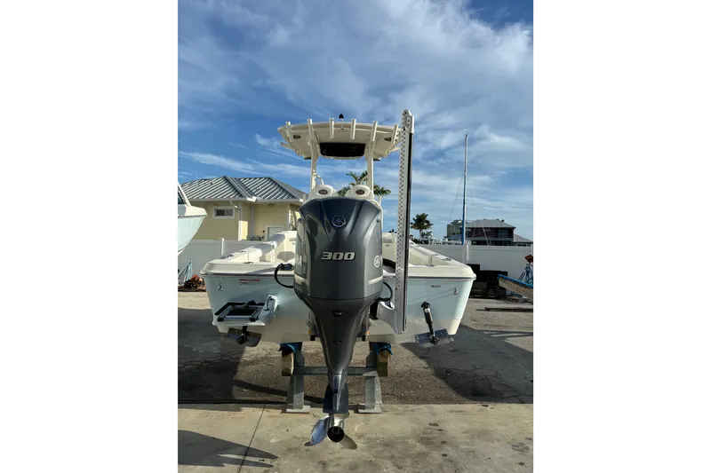 Slide: The Image of 2017 Ranger 2510 Bay Ranger boat with powerful outboard motor, docked under clear skies. - 5