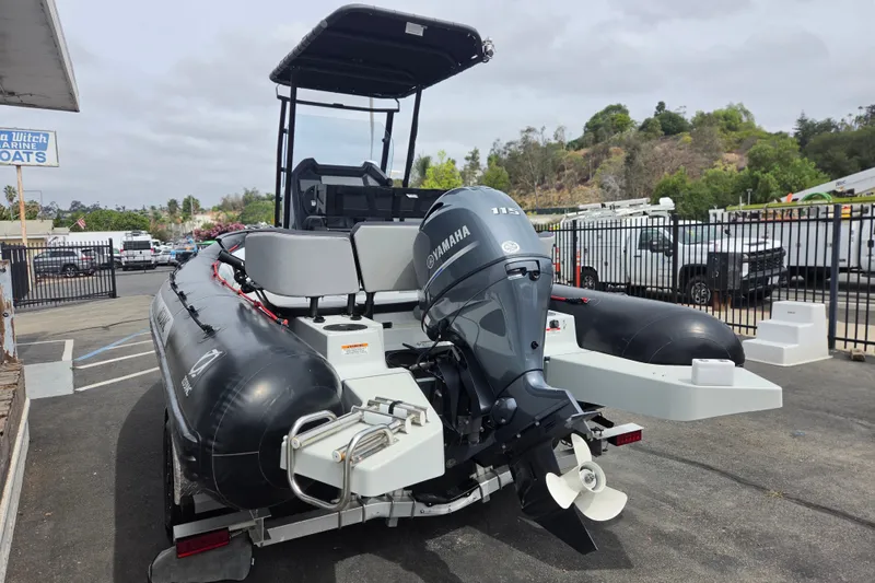 Slide: The Image of 2023 Zodiac Open 5.5 boat with Yamaha engine, parked outdoors at a marina. - 3