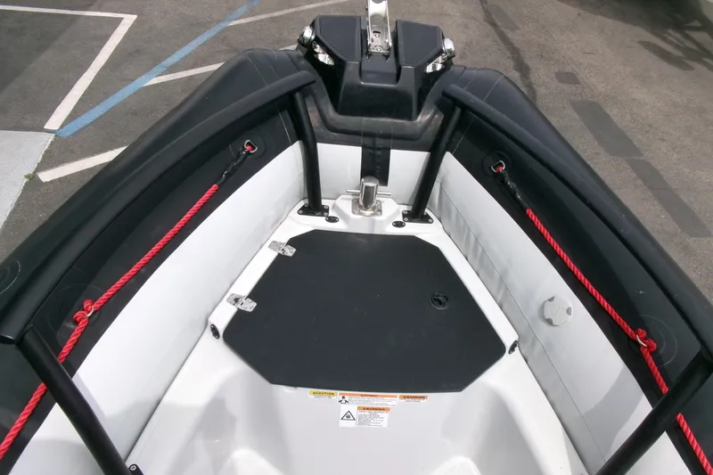 Slide: The Image of 2023 Zodiac Open 5.5 boat interior with red ropes and black seating. - 5