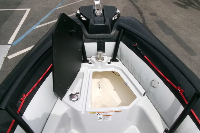 Slide: The Image of 2023 Zodiac Open 5.5 boat interior with storage compartment and red ropes. - 6