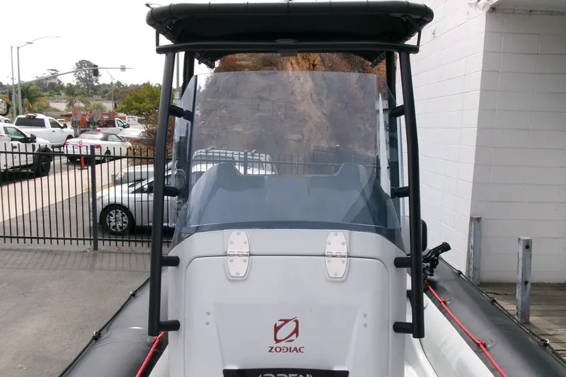 Slide: The Image of 2023 Zodiac Open 5.5 boat, front view, parked outdoors near a fence. - 9
