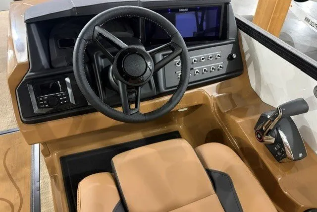 Slide: The Image of 2027 Alera M23L boat cockpit with steering wheel, control panel, and tan seating. - 14